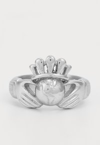 Anillo de estilo Claddagh en plata que presenta dos manos sosteniendo un globo con un diseño en forma de corona encima, sobre un fondo blanco liso.