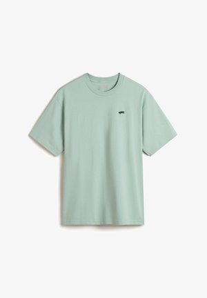 T-shirt en coton vert menthe avec un col rond, des manches courtes et un petit logo graphique noir sur la poitrine gauche. Texture douce et lisse.