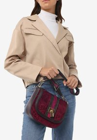 Borsa in suede bordeaux con dettagli grigi e una chiusura dorata. Presenta un design a righe con dettagli floreali in rilievo e una tracolla regolabile.