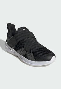 Baskets de sport noires avec une tige en mesh, des sangles ajustables et une semelle blanche. Présente des accents texturés et un design de bout arrondi.