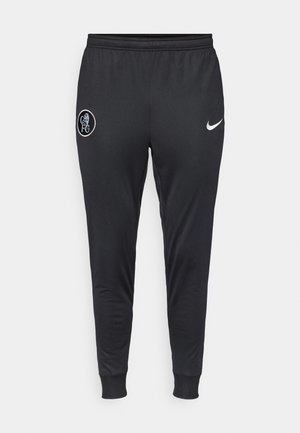 Pantalones de chándal negros de Nike con piernas ajustadas, cinturilla elástica y puños acanalados. Presentan un logo del Chelsea FC en el muslo izquierdo.