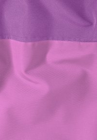 Tissu violet présentant deux sections horizontales, l'une plus foncée et texturée, l'autre plus claire et lisse, avec des coutures visibles le long des bords.