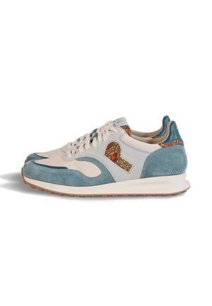Paire de baskets basses en cuir crème avec des panneaux en suède bleu, des accents imprimés léopard, des lacets blancs et des semelles en caoutchouc marron.