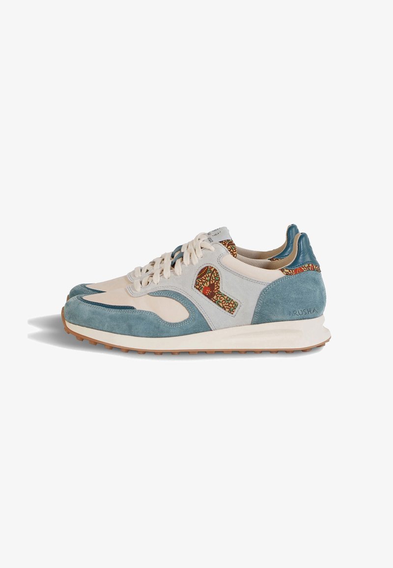 Paire de baskets basses en cuir crème avec des panneaux en suède bleu, des accents imprimés léopard, des lacets blancs et des semelles en caoutchouc marron.