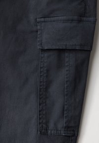 Pantalón cargo azul marino oscuro, hecho de una mezcla de algodón. Cuenta con un bolsillo con solapa y detalles de costura a lo largo de las costuras. Superficie texturizada.