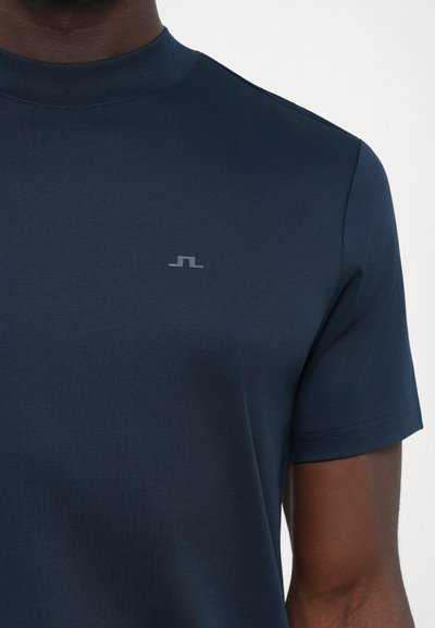 Tricou navy cu mânecă scurtă, cu guler rotund și textură fină, având un mic logo gri pe piept.