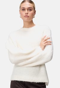 Biely, huňatý sveter s okrúhlym výstrihom a dlh�ými, voľnými rukávmi. Mäkká textura s rebrovaným lemom a uvoľneným strihom.
