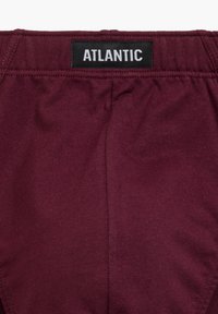 Burgundowa bielizna z teksturowanej tkaniny. Posiada elastyczny pas z czarną metką z napisem "ATLANTIC" w białych literach.