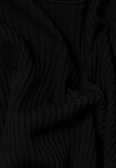 Tessuto a maglia nera a coste spiegazzato con linee verticali in rilievo, morbido e leggermente stropicciato, che riempie l’intera inquadratura.