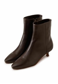 Bottes bottines en cuir marron foncé avec un bout pointu et un petit talon kitten, présentant une texture lisse et une fermeture éclair latérale.