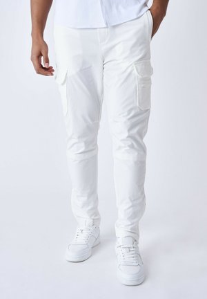 Witte cargo-broek met een slim fit, meerdere zijzakken en een gladde textuur, gecombineerd met witte sportschoenen.