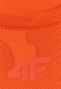Gros plan d'un tissu orange texturé avec le logo en relief "4F" imprimé sur la surface.