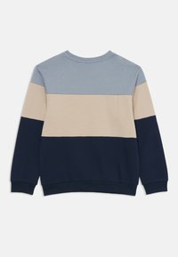 Dolgimi rokavi skrajšan pulover s krožnim izrezom, obarvan s horizontalnimi barvnimi bloki v svetlo modri, bež in temno modri barvi, prikazan s hrbtne strani na beli podlagi.