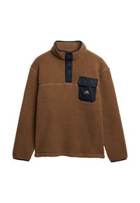 Brown fleece pullover with high collar, snap buttons, and navy chest pocket. Textured fabric and relaxed fit with black accents at cuffs.