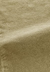 Olivgrüner Cord-Stoff mit ausgeprägten vertikalen Rillen, weicher Textur und glatter Oberfläche, geeignet für Polsterungen oder Bekleidung.