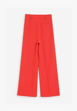 Pantalon rouge à jambes larges, taille haute, avec deux boutons sur la ceinture et une poche latérale unique, sur fond blanc.