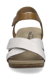Witte en tan leren sandaal met kruisbanden, een zachte zool en een gestructureerde kurken zool. Verstelbare enkelriem voor de juiste pasvorm.