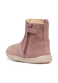 Botín de ante rosa con cremallera lateral, bordes con volantes y pequeños patrones de corazones. Suela de goma con la marca "GEOX". Forro interior suave.