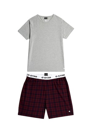 Grijs T-shirt met korte mouwen gecombineerd met donkerrode en zwarte geruite shorts met een witte elastische tailleband met "G-STAR" branding.