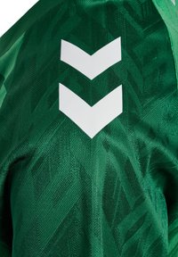 Groen sportshirt met een textuurpatroon en een wit chevronlogo rechtsboven. Gemaakt van lichtgewicht, ademend materiaal.