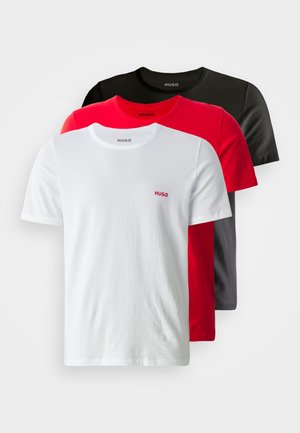 Set di tre t-shirt in bianco, rosso e nero. Ognuna ha un collo rotondo e maniche corte, con un piccolo logo "HUGO" sul petto.