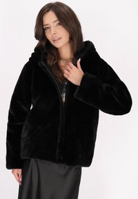 Sort faux fur hoodie jakke med brede ærmer, en frontlynlås og en blød tekstur. Har en stor hætte og accentueret krave.