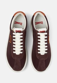 Burgundy suede sneakers with white laces and a tan leather accent. Features a rounded toe and logo details on the tongue and side.