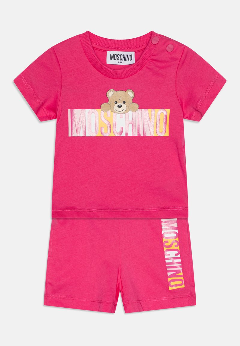 Conjunto para toddler en color rosa que incluye una camiseta de manga corta con un gráfico de un oso y un logo, acompañado de pantalones cortos a juego. Fabricado en suave algodón.