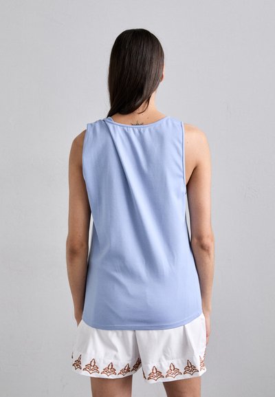 Light blue sleeveless top featuring a round neckline. The fabric appears soft, with a smooth texture, and a relaxed fit at the back.