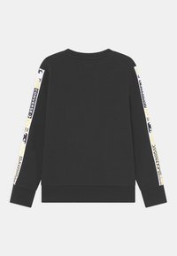 Sudadera negra de manga larga con puños y dobladillo acanalados, que presenta texto y patrones de marca multicolores en las mangas.
