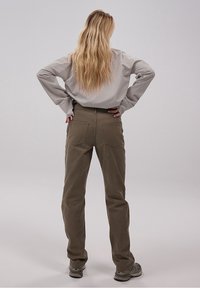 Pantalons marron à jambe droite en matériau durable, dotés de deux poches arrière et d'une taille standard. Portés avec un haut gris clair.