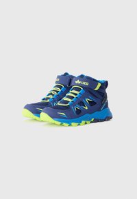 Chaussures de randonnée montantes en bleu marine avec des accents vert fluo. Comprend des panneaux en mesh, une semelle en caoutchouc robuste et une sangle réglable au-dessus des lacets.