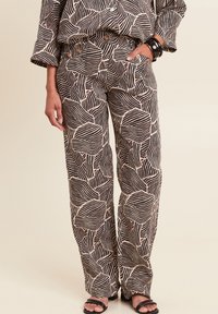 Zwarte en beige gestreepte broek met een vloeiend ontwerp en bladvormige patronen, gemaakt van lichtgewicht stof. Beschikt over zijzakken en een relaxte pasvorm.