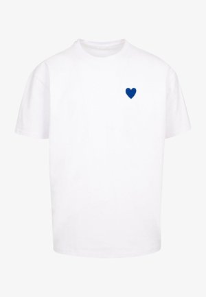 T-shirt in cotone bianco con grafica a cuore blu nella zona sinistra del petto. Maniche corte e design a girocollo.