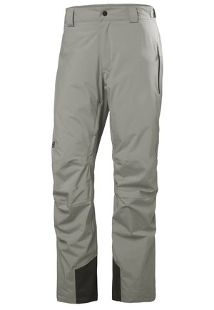 Pantalones impermeables de color gris claro, hechos de material sintético con una textura suave. Presenta detalles en negro en la parte inferior y bolsillos laterales con cremallera.