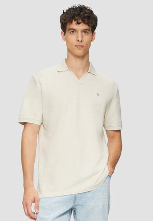 Beige Poloshirt mit kurzen Ärmeln und V-Ausschnitt, mit kleinem Logo auf der linken Seite. Hergestellt aus weichem, strukturiertem Stoff.