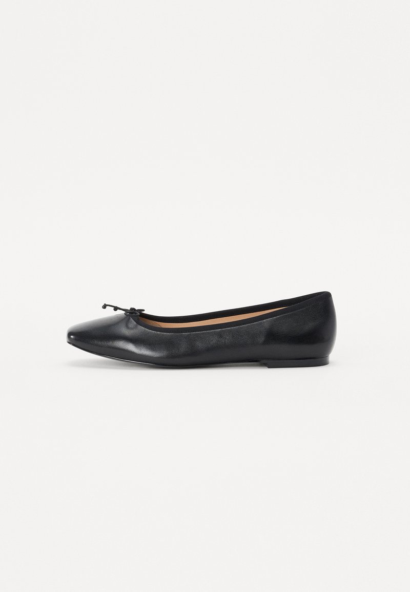 Zwarte ballerina met een puntige neus, gemaakt van soepel leer. Beschikt over een klein strikaccent aan de voorkant en een laag profiel rubberen zool.