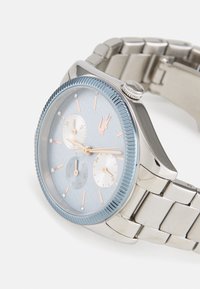 Orologio da polso argento con lunetta blu, quadrante azzurro, dettagli in oro rosa, tre sottoquadranti e cinturino in acciaio inossidabile.