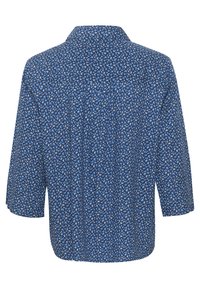 Chemise à motifs bleus à manches courtes, dotée d'un col et d'une coupe décontractée. Le tissu a une texture douce et de petits motifs floraux.