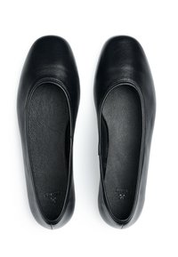 Schwarze Leder-Balletflats mit abgerundeter Zehenpartie und glatter Oberfläche. Das Innere verfügt über ein strukturiertes Futter für zusätzlichen Komfort. Keine sichtbaren Beschläge.