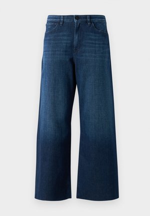 Cowboy de ganga azul-escuro de perna larga com botão frontal, passagens para cinto e design clássico de cinco bolsos sobre fundo simples.