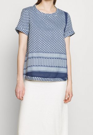 Top blu navy a maniche corte con motivi geometrici, caratterizzato da un collo rotondo e una vestibilità ampia. Accentuato da righe orizzontali nella parte inferiore.