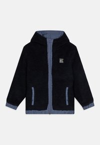 Svart fleecejakke med hette, kontrasterende blå fôr, glidelåsfront og to sidelommer. Har et brodert logo på brystet.