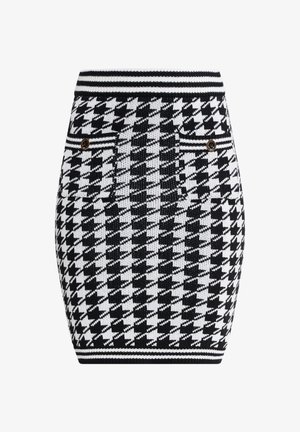 Szydełkowana spódnica ołówkowa w czarno-białym wzorze w karo. Posiada ribbed w pasie oraz dwie przednie kieszenie z guzikami w złotym odcieniu.