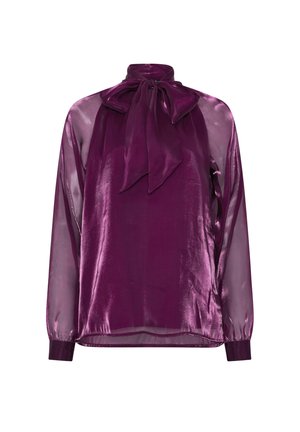 Blusa de terciopelo púrpura con cuello alto y un gran lazo en el cuello, mangas largas transparentes y puños ajustados en las muñecas.