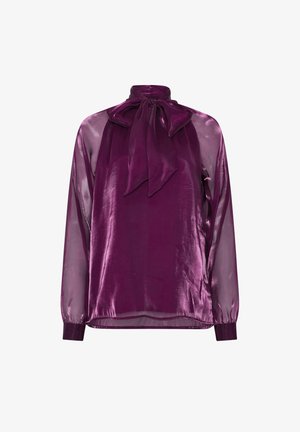 Blusa de terciopelo púrpura con cuello alto y un gran lazo en el cuello, mangas largas transparentes y puños ajustados en las muñecas.