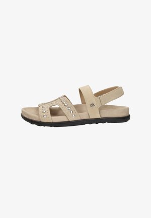 Sandale beige à bout ouvert avec clous argentés, bride ajustable à la cheville en velcro, semelle rembourrée et semelle extérieure en caoutchouc noir.
