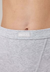 Graue Boxershorts mit weicher Textur, versehen mit einem "SNOCKS"-Logostick auf dem elastischen Bund und einem schlichten Design ohne Muster.