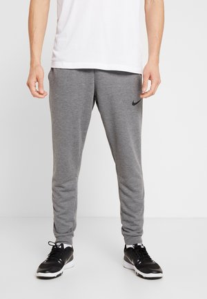 Grijze joggerbroeken gemaakt van zachte stof met een taps toelopende pasvorm, met een klein zwart Nike-logo op de dij en elastische boorden bij de enkels.