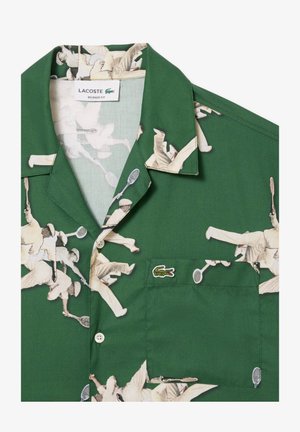 Zeleno kratko-služno srajco z retro tiskanjem teniškega igralca, sproščen kroj, žep na prsih in majhna vezenina logotipa na žepu.